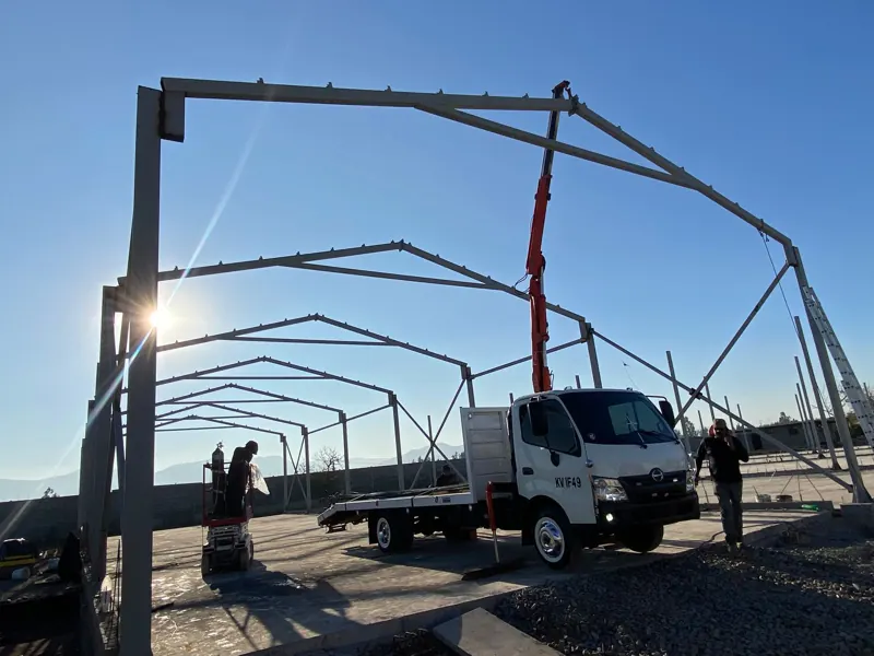 Montaje de la estructura de un galpón con camión pluma